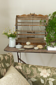 Bird cage on side table in living room of Canterbury home England UK