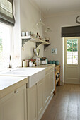 Open shelf and sink at window of iving Canterbury kitchen England UK