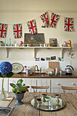 Union Jack bunting in Suffolk kitchen with silver and kitchenware, England, UK