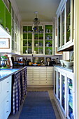 Glass fronted cupboards in galley kitchen of Massachusetts home, New England, USA