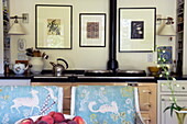 Backofen und Kunstwerk mit gepolsterten Stühlen in der Küche eines Hauses in Massachusetts, Neuengland, USA
