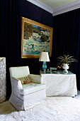 Armchair seating with table in dark blue bedroom of Massachusetts home, New England, USA
