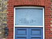 Fish detail in frosted glass above doorway in Broadstairs, Kent, England, UK