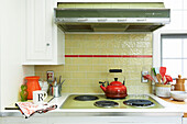 Red kettle on electric hob with tiled splashback in Berkshires home, Massachusetts, Connecticut, USA