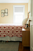 Red embroidered bedspread on double bed in Berkshires home, Massachusetts, Connecticut, USA