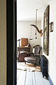 Buttoned chair with vintage mirror above radiator in Hastings home, East Sussex, England, UK