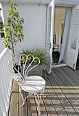 Decked garden balcony on seaside cottage with white wirework chair in Dover, UK