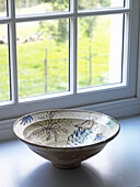 Hand painted bowl on windowsill of Gloucestershire farmhouse, England, UK