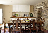 Wooden table and chairs in open plan kitchen of Laughame townhouse, Wales, UK