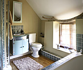 Modern bathroom with low window in Welsh cottage interior, UK