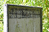 Peeling paint on signpost of woodland chapel in Shropshire, England, UK