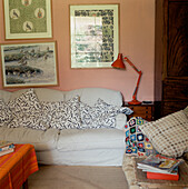 Unaufgeräumtes Wohnzimmer im Landhausstil mit Sofa und schiefen Bildern an der Wand