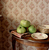 Dining room side table with display of cooking apples and vintage crockery
