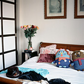 Kleines weißes Schlafzimmer mit Doppelbett und Kuscheltieren