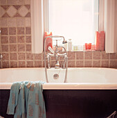 Detail eines gefliesten Badezimmers mit Roll-Top-Badewanne