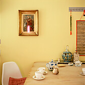 Detail von Küchentisch und Haushaltswaren mit gelb gestrichenen Wänden