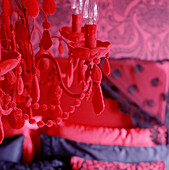 Detail eines roten Kronleuchters in einem rot-schwarzen Zimmer