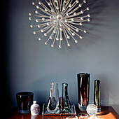 Dressing table detail in bedroom with vintage coloured glassware and a retro wall light