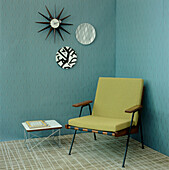 Green and turquoise contemporary Art Deco style living room detail with textured wallpaper armchair and home wares
