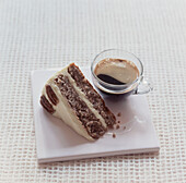 Slice of walnut cake with a cup of black coffee