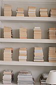 Offene Regale mit gestapelten Büchern in einem modernen Heimbüro
