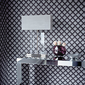 Grey and black bold patterned wallpapered room mirrored side table with ornament