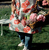 Woman in her garden collecting flowers in a basket
