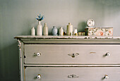 Painted vintage style chest of draws in a bedroom with personal belongings