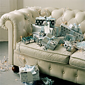 White leather chesterfield sofa covered in wrapped Christmas presents
