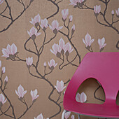 Floral wallpaper on a wall with a pink chair