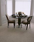 Neutral coloured carpeted dining room with dining table setting and chairs