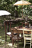 Sonnenschirme beschatten Tisch und Stühle im Garten, UK