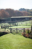 Elevated view of gate, fence and farm buildings, United Kingdom