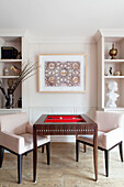 Pair of matching chairs at games table in contemporary London home England UK