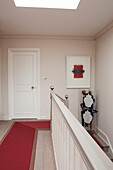 Red carpet runner in landing hallway of contemporary London home England UK