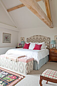 Co-ordinated blanket box and headboard in beamed bedroom of Wiltshire country house England UK