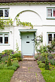 Light green paintwork on exterior of whitewashed Surrey cottage England UK