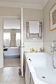 Wall mounted towel rack in white tiled ensuite bathroom of contemporary Chelsea home London UK