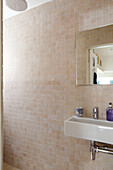 Tiled bathroom with mirror and sink in contemporary Chelsea home London UK