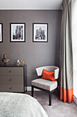 Comfortable double bedroom in soft grey with bright orange details