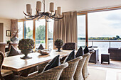 Hydrangea on dining table in open plan room with a view of lake, England, UK