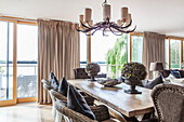 Dining table with wicker chairs and view of lake, England, UK