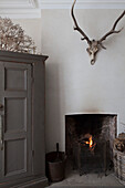 Antlers above lit fire with coal bucket in Hove home East Sussex England UK