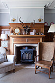 Antique chair at wooden fireside in Haslemere home, Surrey, UK