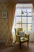 Yellow armchair in window of historic Somerset country house UK