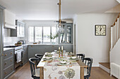 Schnittblumen und Läufer auf einem Tisch in einer offenen Küche in einem Londoner Haus UK