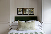 Grün und weiß gestreifte Bettwäsche und botanische Drucke in einem Londoner Haus UK