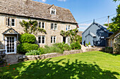 Sunlit garden of old stone cottage in Cirencester Gloucestershire UK