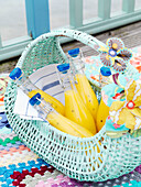 Bottles of pineapple juice in a turquoise painted basket