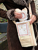 Woman putting heart shaped doily into shoulder bag Brighton, East Sussex UK